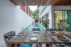une salle à manger avec une table et une piscine dans l'établissement New Primrose Pool Villa Your Own Secluded Paradise, à Ban Saiyuan (1)