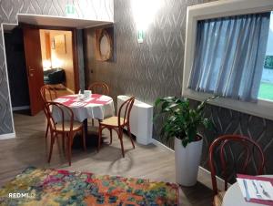 a dining room with a table and chairs at BF SUITE Foresteria Bellusci in Rho +14 photos
