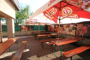 a group of wooden tables and benches with an umbrella at Penzión Pagy in Višňové