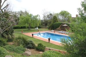 
a pool with a tennis court and a swimming pool at Mas Vilosa Bed and Breakfast in Corçà
