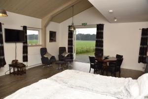 a bedroom with a bed and a table and chairs at Munnickenheide Buitengewoon Overnachten in Terheijden