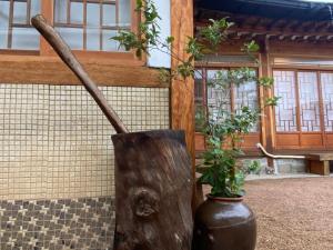 a wooden stick in a vase with a plant in it at Bonjour Hanok in Gyeongju
