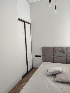 una camera da letto con un letto con due cuscini sopra di Senamiesčio apartamentai a Klaipėda
