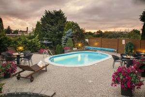 a patio with a pool and chairs and a table at Villa Grande - Apartmány in Olomouc