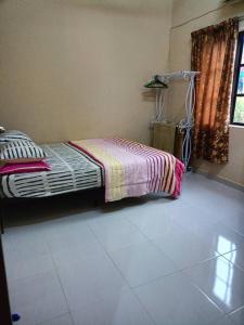 a bedroom with a bed with a striped blanket at DKayangan Homestay, Kuantan in Kuantan
