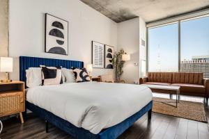 a bedroom with a large bed and a couch at Boulevard Stays Highrise STU Sky Pool Parking Gym 19 in Phoenix