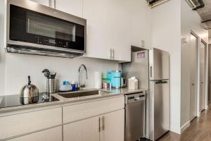 a kitchen with a stainless steel refrigerator and a microwave at Boulevard Stays Highrise STU Sky Pool Parking Gym 22 in Phoenix