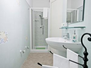 een witte badkamer met een wastafel en een douche bij Pian di luna in Sarzana +16 foto's