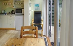 a kitchen with two chairs and a table and a kitchen with a refrigerator at One-Bedroom Holiday Home In Vejers Strand in Vejers Strand