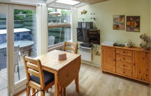 a kitchen with a wooden table and chairs in a room at One-Bedroom Holiday Home In Vejers Strand in Vejers Strand