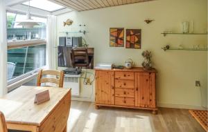 a kitchen with a wooden table and a wooden cabinet at One-Bedroom Holiday Home In Vejers Strand in Vejers Strand