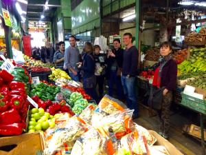 a group of people standing in a market with produce at The Travelling Chile in Valparaíso