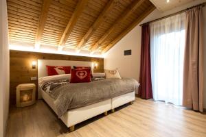a bedroom with a bed and a large window at Residence Villa Artic in Campitello di Fassa