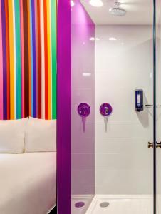 una ducha colorida con una cama y una cortina colorida en Ibis Styles Mexico Reforma, en Ciudad de México