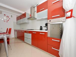 cocina con armarios rojos y mesa en Apartment Nikolina en Trogir