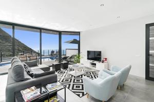 ein Wohnzimmer mit Blick auf das Meer in der Unterkunft Villa Calheta Charm by Villa Plus in Arco da Calheta