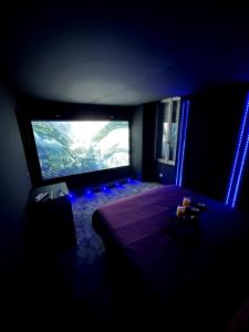a dark room with a bed and a large window at Ciné-Ponot in Le Puy en Velay