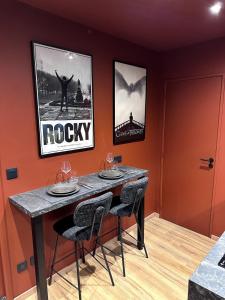 a dining room with a table and three chairs at Ciné-Ponot in Le Puy en Velay +7 photos