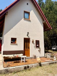 a dog is standing in front of a house at Jozin put -planinska kuća in Blidinje
