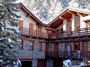 a building with a snow covered mountain in the background at Alpine Bliss A Cosy Retreat in Antey-Saint-André