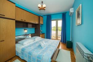 a blue bedroom with a bed and a window at Apartment Anica in Rab