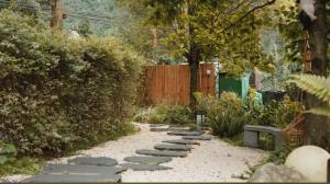 a garden with a stone path and a fence at M Country Road 山行野奢影院温泉民宿 in Dujiangyan