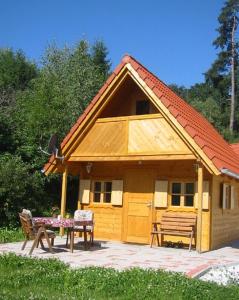 ein kleines Haus mit einem Tisch und einer Bank davor in der Unterkunft Ferienhaus Beme in Spielberg