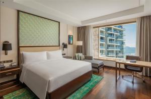 a hotel room with a bed and a desk and a window at Hilton Da Nang in Da Nang +77 photos