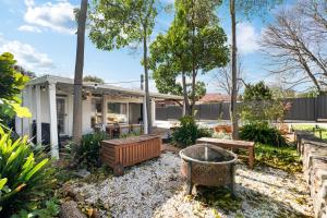 une arrière-cour avec un foyer extérieur et une maison dans l'établissement Herringbone Cottage - Unique Garden Escape CBD, à Fullarton