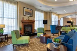 a lobby with blue and green chairs and a fireplace at Comfort Suites Barstow near I-15 in Barstow