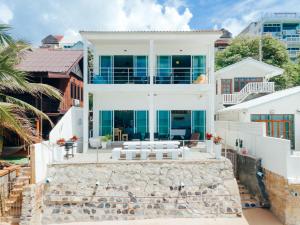 Ban PhalaにあるPhaladise Beach Villa at Phala Beach, Ban Changの石壁の大白い家
