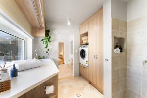 une cuisine avec un évier et une machine à laver dans l'établissement Herringbone Cottage - Unique Garden Escape CBD, à Fullarton 35 autres photos