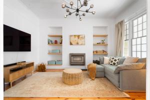 un salon avec un canapé et une cheminée dans l'établissement Herringbone Cottage - Unique Garden Escape CBD, à Fullarton