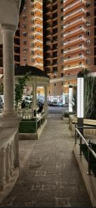 a walkway with a gazebo in a city with tall buildings at Апарт 2 комн Гринплаза in Aktau