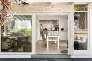 une porte ouverte menant à une salle à manger avec une table dans l'établissement Herringbone Cottage - Unique Garden Escape CBD, à Fullarton