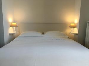 a white bed in a room with two lamps at Palais Sapho Residence in Nice