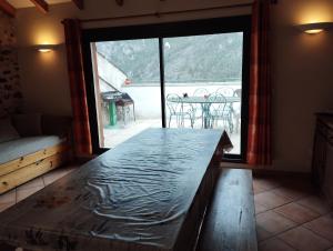 a room with a large window and a table with a view at Bergerie " Le Cortal " in Nohèdes