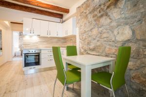 cocina con mesa blanca y sillas verdes en Apartments Sara en Split