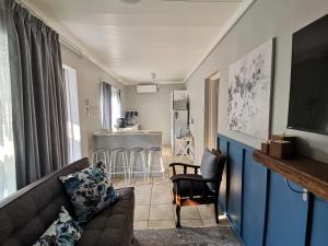 a living room with a couch and a kitchen at J's Haven Self-Catering in Kimberley
