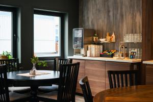 a dining room with a table and chairs and a counter at Northern Light Hotel in Boden