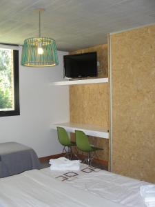 a bedroom with a bed and two chairs and a tv at Casa Huarpes MDP en Bosque Peralta Ramos in Mar del Plata