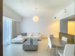 una sala de estar con una mesa y un sofá en Stylish 1BR Apt in Gate Tower 3, en Abu Dabi