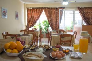 a table with plates of food and oranges on it at Dorana Apartments & Trekking Hotel in Diafani