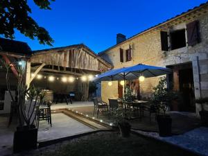 patio esterno con tavolo e ombrellone di La Métairie du Clos Saint Louis a Montréal