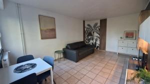 a living room with a couch and a table at Prenepla in Ornex