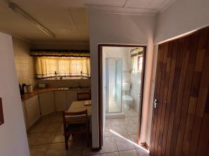 una cucina con porta che si apre su un bagno di Pavlovna Cozy 2 Cottage a Himeville