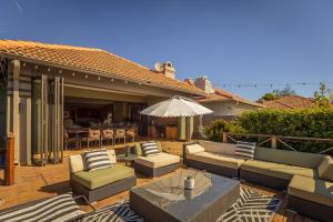a patio with couches and a table and an umbrella at Pecanwood Retreat in Hartbeespoort