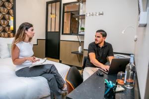a man and woman sitting in a room with a laptop at WS Notre-Dame - Jussieu in Paris