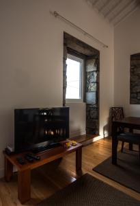 a living room with a table and a large screen tv at Casa do Simão in Nordeste