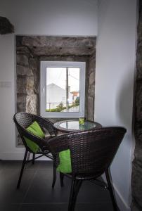 a table and chairs in a room with a window at Casa do Simão in Nordeste